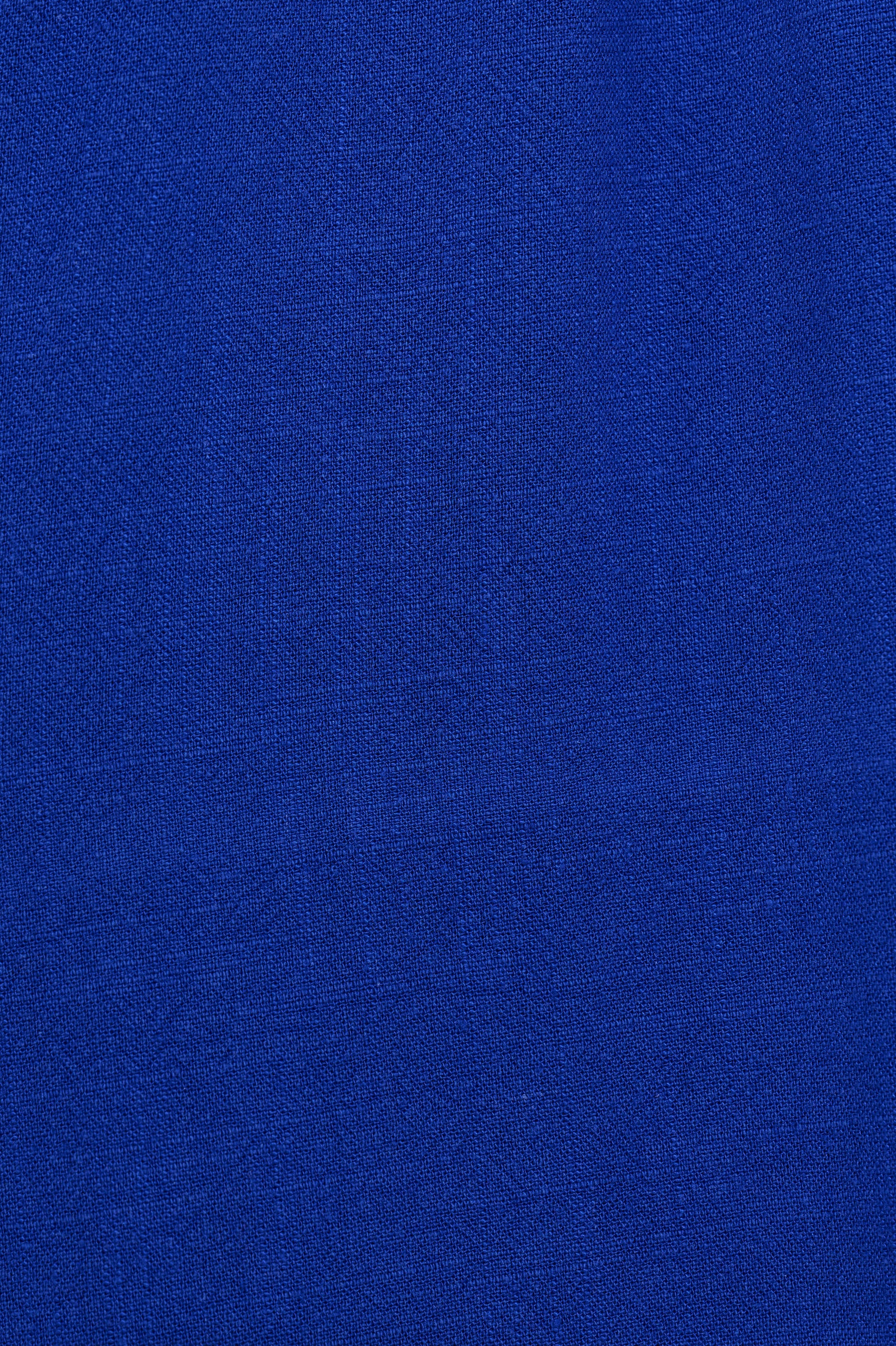 A close-up of a vibrant royal blue textured fabric, showing a fine woven pattern.