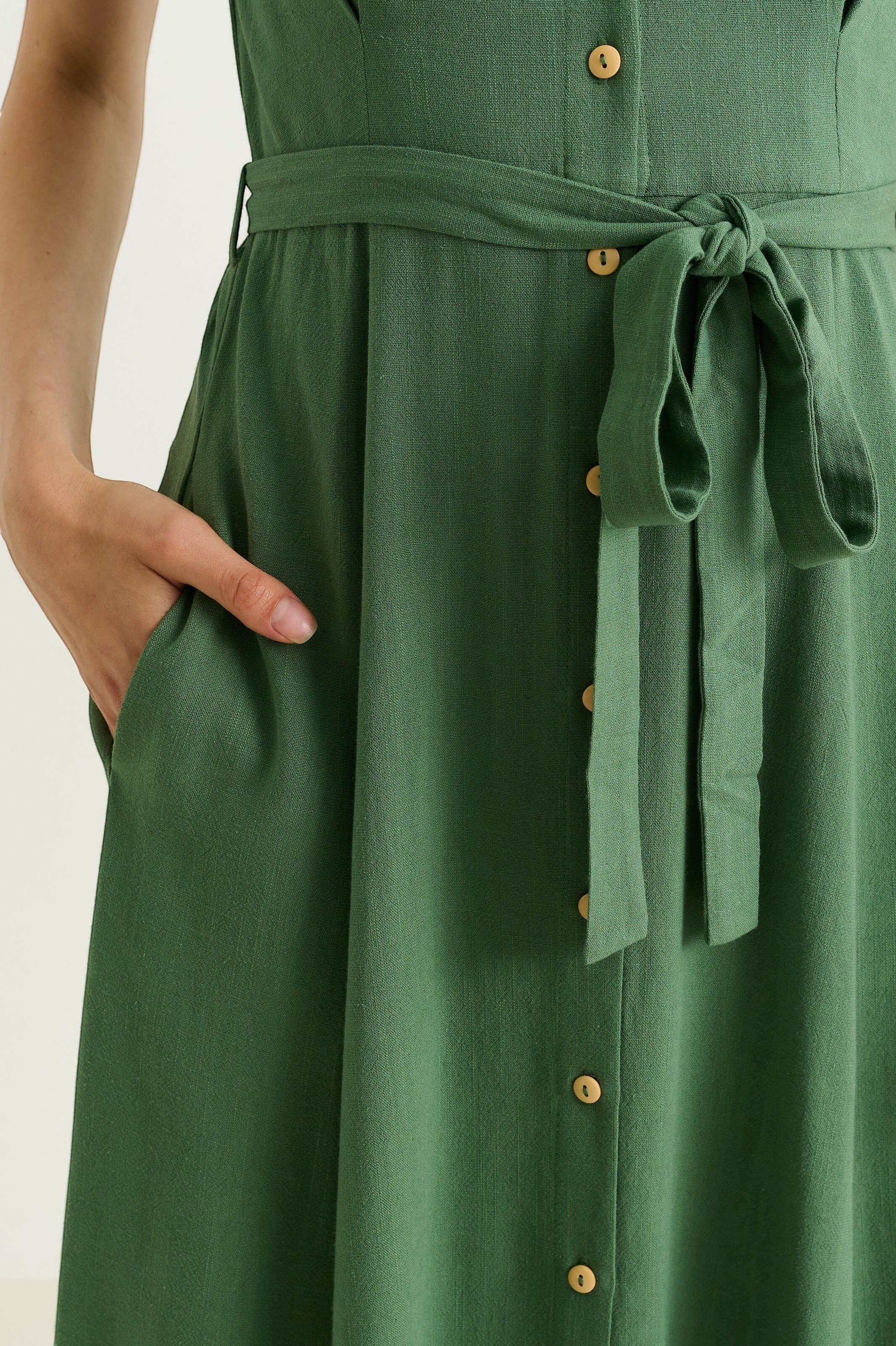 green linen mix midi shirt dress with self belt, button front, and side pockets.