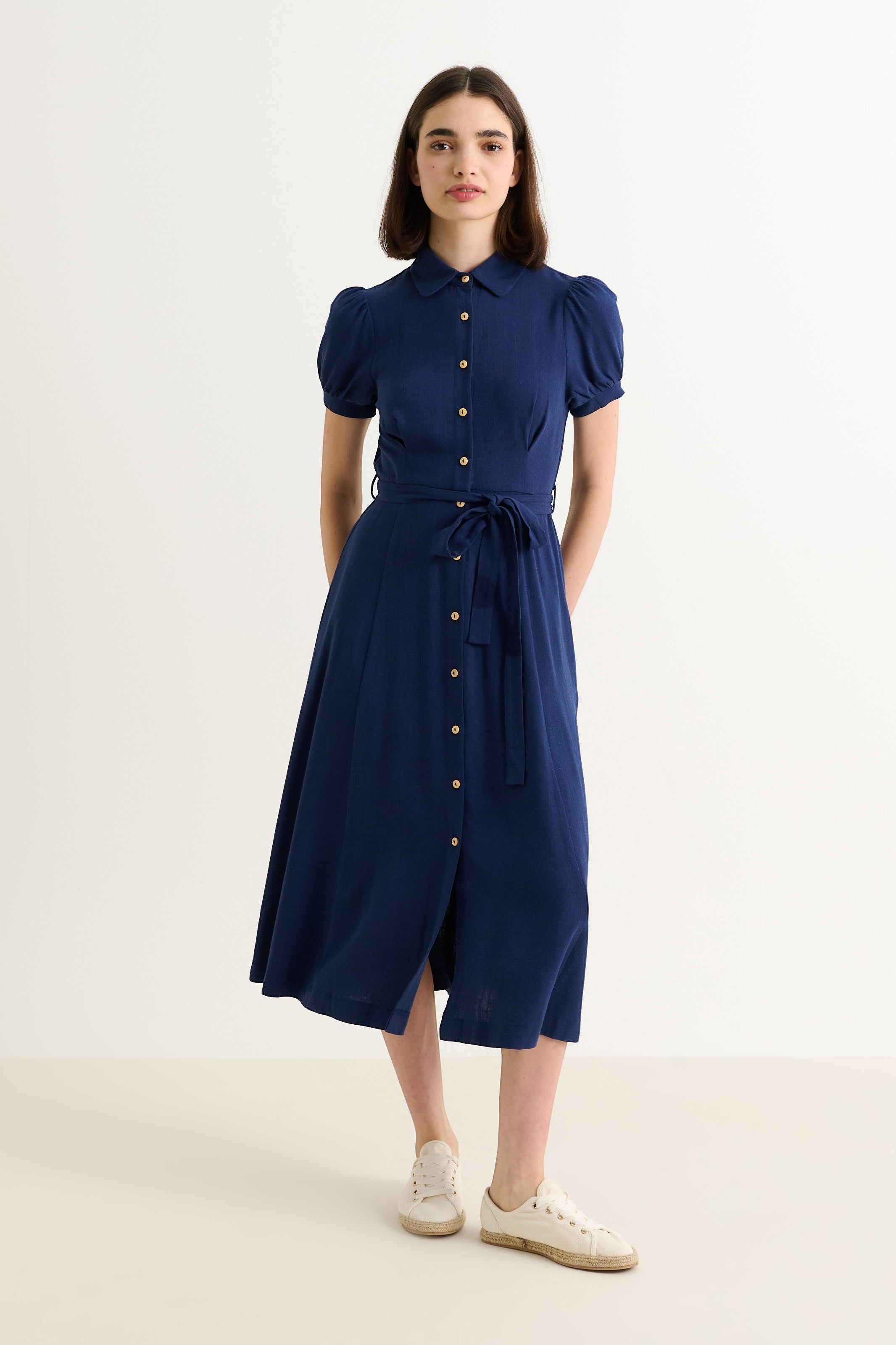 Navy blue linen mix midi shirt dress with puff sleeves, rounded collar, self-tie belt, and button-through front. Model is 5'8" and wearing size 8.