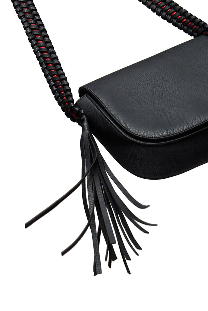 Louche Clay black saddle bag styled — worn cross-body for a summer outfit, with inside pocket and tassel detail.