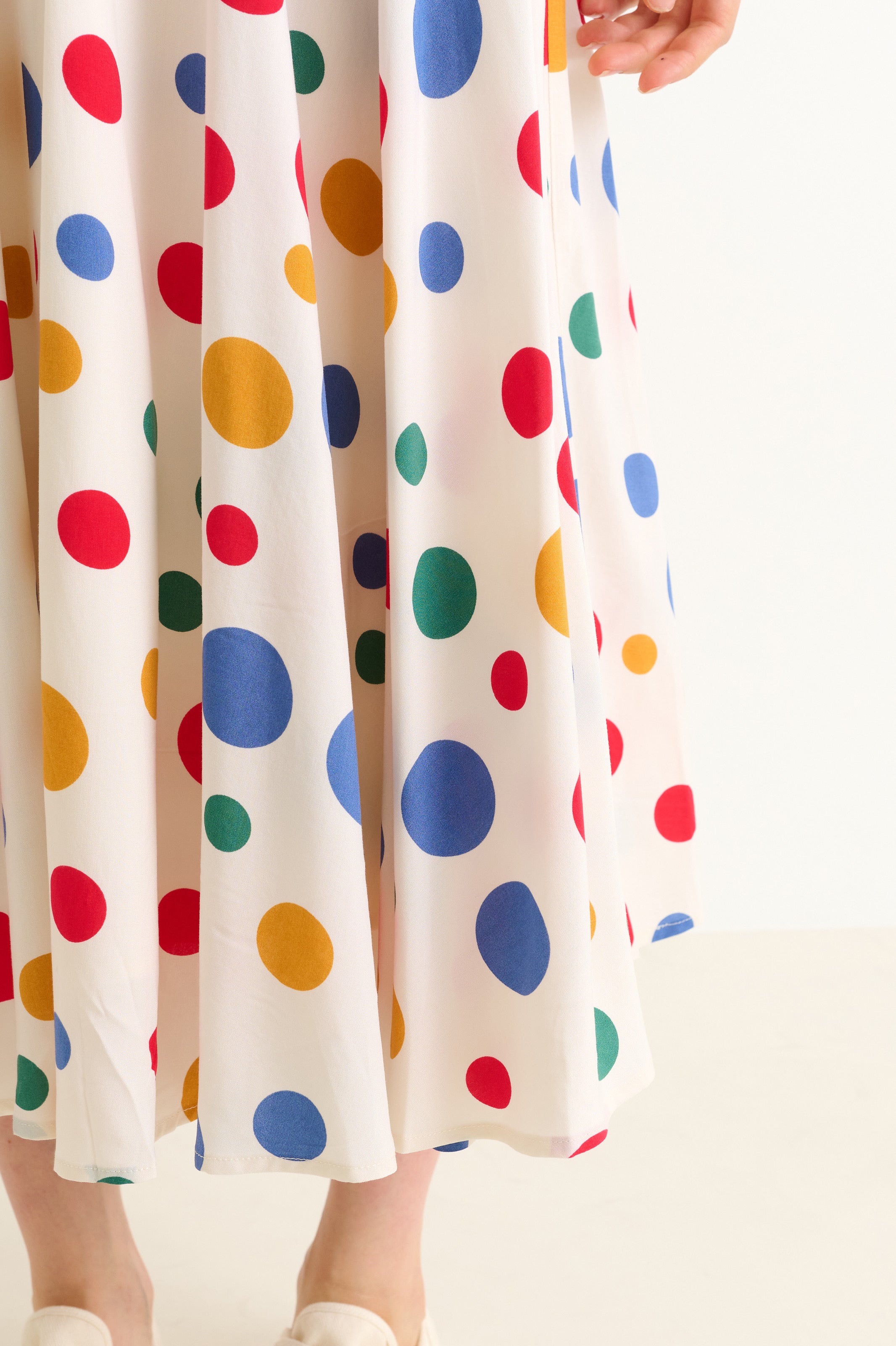 Colorful polka dot skirt being held up against a white background