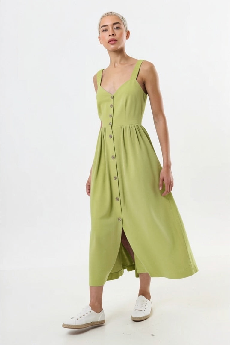 Woman wearing a green dress with buttons on a white background