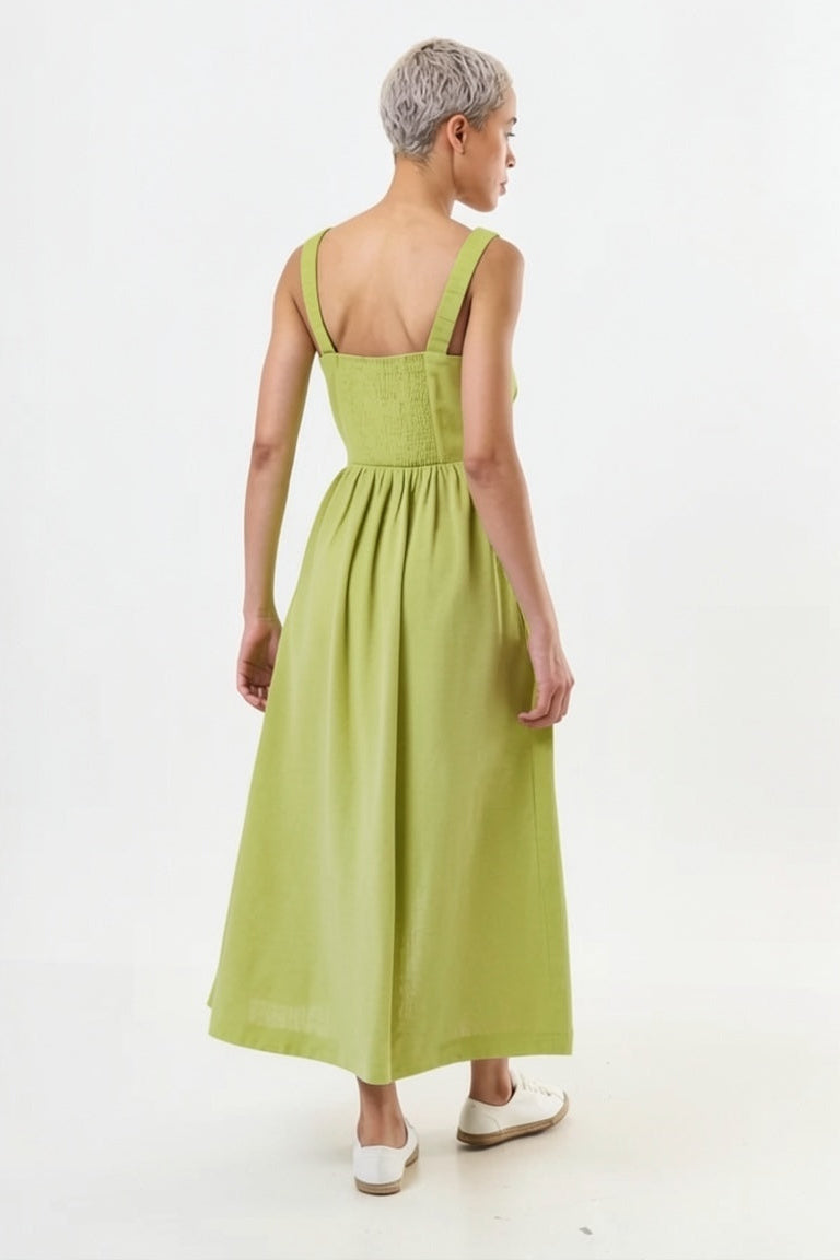 Woman wearing a green dress with thin straps on a white background