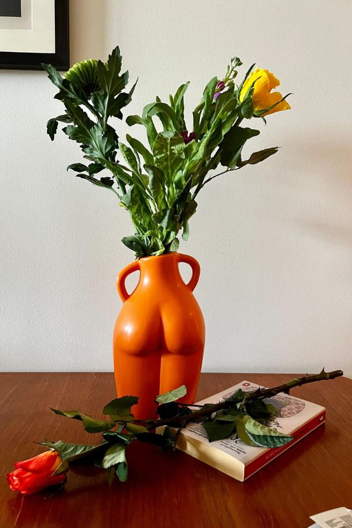 Orange figure vase with flowers