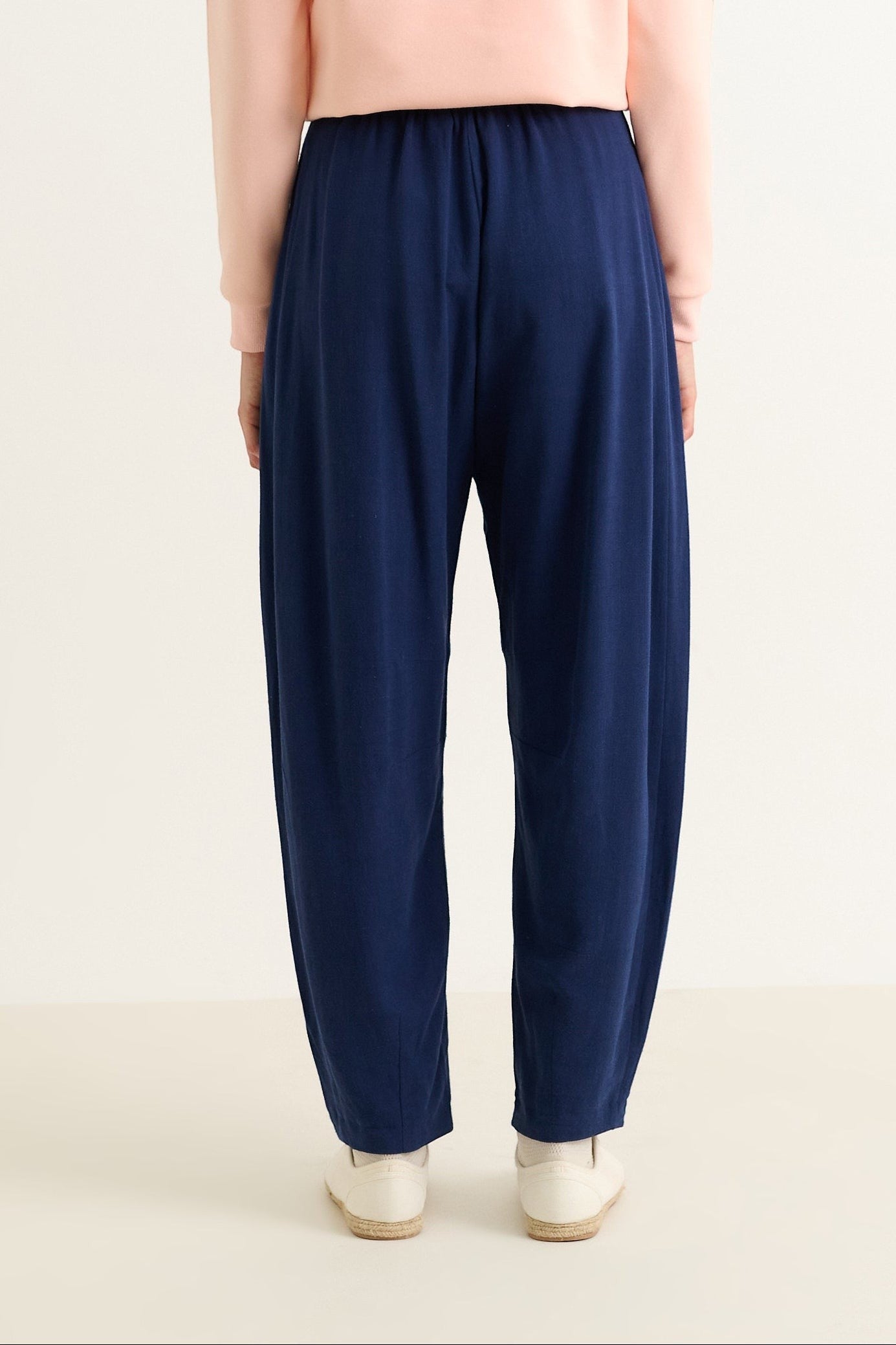 Navy linen mix barrel trousers with elasticated waist and pockets, worn by a model with a light pink top and espadrilles.