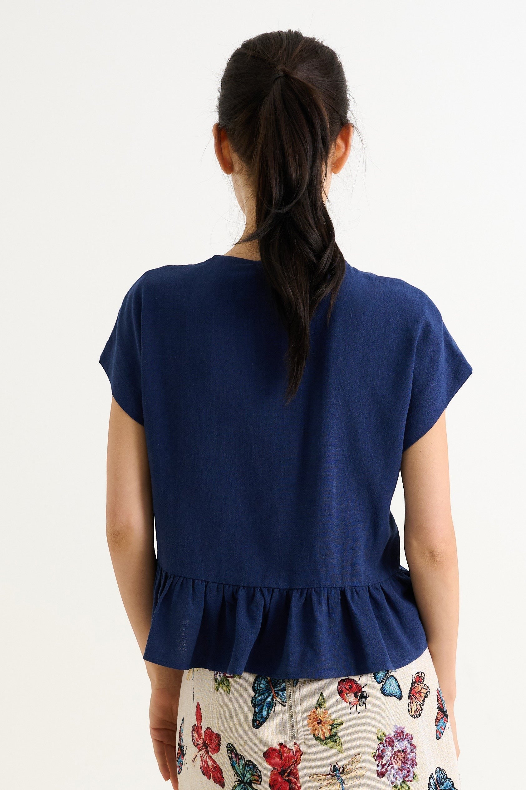 navy blue linen blend top with extended shoulders and a flutter frill hem