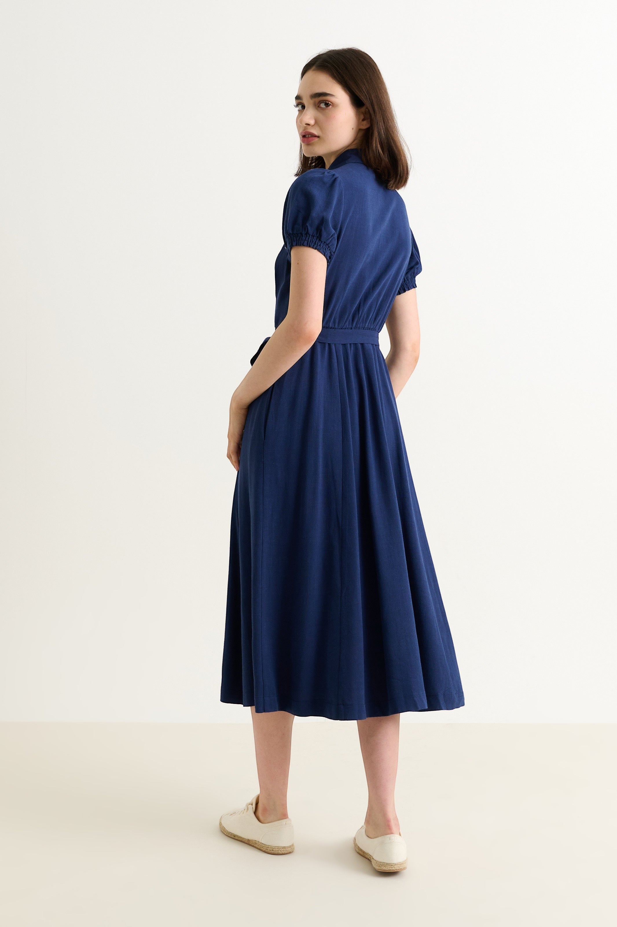 navy blue linen mix midi shirt dress with puff sleeves, rounded collar, self belt, and pockets. Model is 5'8" and wearing a size 8